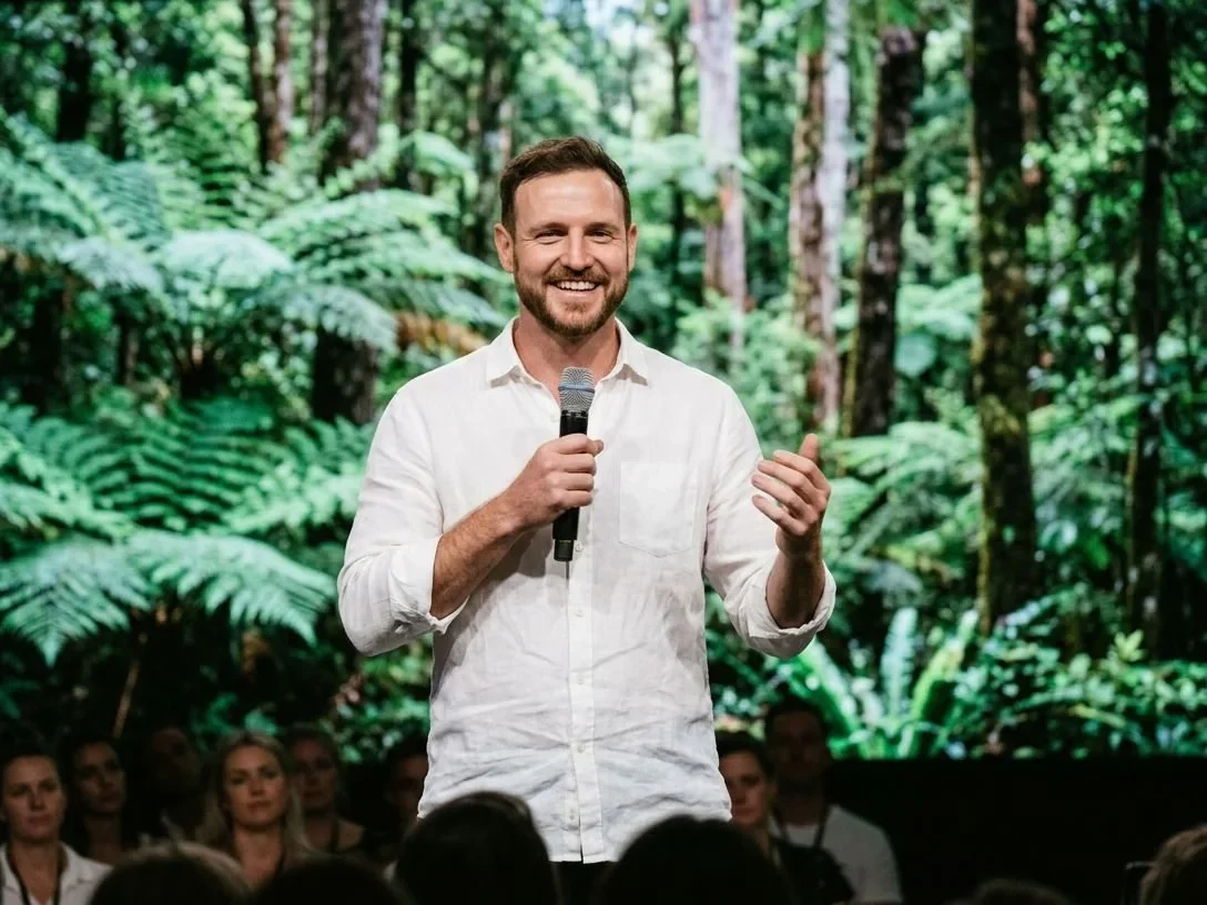 Cameron Quin on stage with a microphone